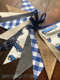 a blue and white gingham bunting banner with cars on it, sitting on top of a wooden floor