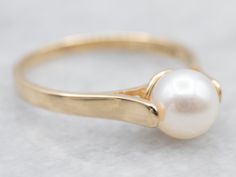 This classic yellow gold solitaire ring with a lustrous pearl at its center exudes timeless elegance. Expertly crafted to the highest standards, this ring is sure to become a treasured heirloom.Metal: 14K Yellow GoldGem: PearlGem Measurements: 6.2 mm, RoundRing Size: 6.50Marks: "14KWH" Stamped on the inside band Luxury Everyday Yellow Gold Pearl Ring, Pearl Rings In Gold, Pearl Engagement Ring Vintage, Pearl Ring Design, Pearl Ring Simple, Vintage Pearl Ring, Natural Pearl Ring, Pearl Rings Vintage, Yellow Gold Solitaire Ring