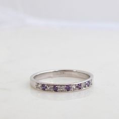 "Beautifully made Simple Half eternity Band Featuring 6 Diamonds and 5 Alexandrite gemstones. Formed as a whole and perfectly round This handmade ring is most Elegant and precious. A real joy to Own, comfortable and Rich in Sparkling presence! Featuring 11 Stones in Total. Six Diamonds (vs) 1.5mm for a Total carat weight of 0.09 Minimum And Five 1.5mm Alexandrite Gemstones (Lab created ones, Real one Are very, Very rare to come by in these small sizes). The Ring weighs approx 3-3.2Grams of Solid Diamond Multi-stone Stackable Rings Round Cut, Diamond Multi-stone Stackable Rings, Cubic Zirconia Anniversary Gemstone Round Cut, Anniversary Cubic Zirconia Gemstone Round Cut, Diamond Multi-stone Stackable Rings With Round Band, Classic Multi-stone Stackable Rings For Anniversary, Round Gemstones For Anniversary Fine Jewelry, Diamond Birthstone Gemstones For Anniversary, White Gold Amethyst Diamond Multi-stone Ring