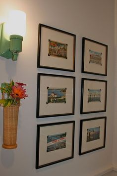 there is a vase with flowers on the wall next to some pictures and a lamp