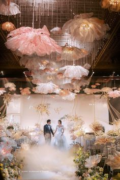 two people standing in front of a display with umbrellas hanging from the ceiling