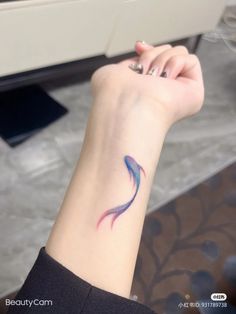 a woman's arm with a small tattoo on the left side of her wrist