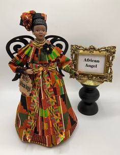 "Celebrate pride and beauty with our line of AFRICAN ANGEL TREETOPPERS and give your loved ones the gift of representation that reflects images of you and your family. This unique Porcelain AFRICAN ANGEL, adds Afrocentric style to your Holiday Decorating. Proudly place this AFRICAN ANGEL on top of your Christmas tree as a tree topper, place her on the table as a centerpiece or fireplace mantel to display, where she is surely to be a memorable conversation piece for your guests. OPTIONAL: Clear D African Christmas Tree Decorations, African Inspired Christmas Tree, African Christmas Tree Ideas, African Christmas Tree, African Christmas Decorations, African Angel, Afrocentric Style, African Christmas, Kente Fabric