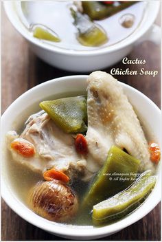 two bowls filled with chicken and vegetables on top of a wooden table