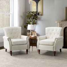 two white chairs sitting next to each other on a rug in front of a window