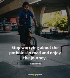 a man riding a bike on top of a cement slab with a quote about stop worrying about the potholes in road and enjoy the journey