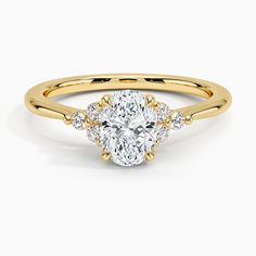 a yellow gold engagement ring with an oval cut diamond and three small round diamonds on the band