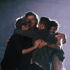 three young men hugging each other in a black and white photo