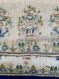 an embroidered cloth with flowers and birds on it