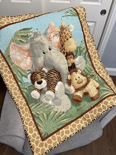 an elephant, giraffe, zebra and other stuffed animals on a blanket