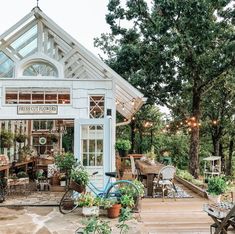 a white building with lots of windows and plants in front of it on a patio