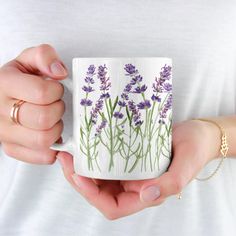 a woman holding a coffee mug with lavender flowers on it