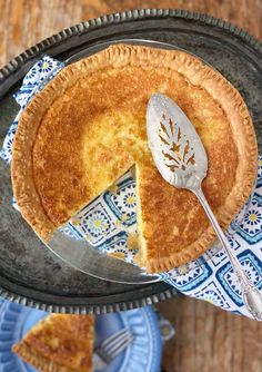 there is a pie on the table with a fork in it and two plates next to it