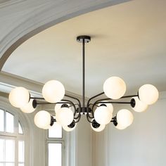 a large chandelier hanging from the ceiling in a room with white walls and windows