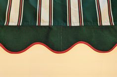 a green and white striped curtain with red trim