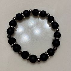 Matte black and gunmetal beaded bracelet with silver spacer beads. Additional gunmetal beaded bracelet optional. The larger beads are 8mm round glass beads. The smaller beads are 5mm iron round beads. The bracelets are approximately 17-17.5 cm in length each. Boys Bracelets, Ankle Bracelets Diy, Black Beaded Bracelets, Bracelets Design, Beads Bracelet Design, Glass Bracelet, Black Bracelets, Pretty Bracelets, Bead Bracelets