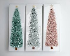 three small christmas trees are on display in white and pink boxes with gold trimmings