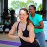 two women are doing yoga outside in the sun