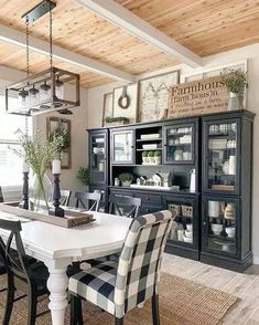 the dining room table is set with black and white checkered chairs, an old china cabinet