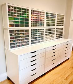 a white dresser with lots of drawers and bins