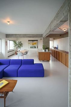 a living room filled with blue couches next to a table