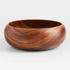 a wooden bowl sitting on top of a white table