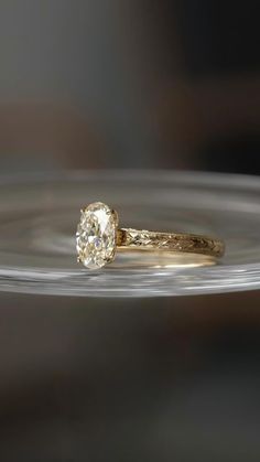 a close up of a ring with a diamond in it on a glass plate,