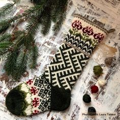 a pair of socks sitting on top of a table next to a christmas tree branch