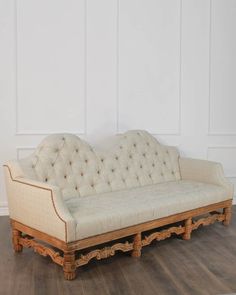 an old couch sitting on top of a hard wood floor next to a white wall