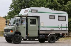 a green truck with a camper on the back