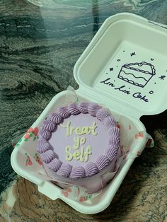 a purple frosted cake in a white plastic container with writing on it that says treat up self