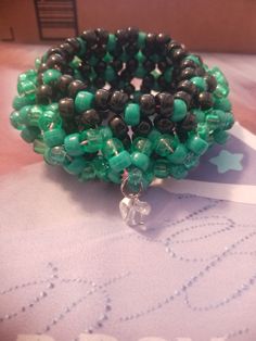 green and black beaded bracelets sitting on top of a table