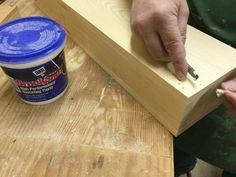 a person is working on some wood with a paintbrush and glue in their hand