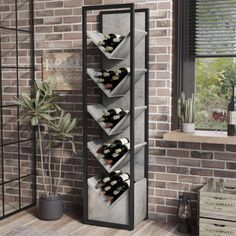 a wine rack with bottles in it next to a brick wall and potted plant