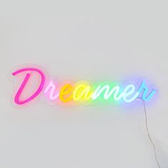 a neon sign that says,'dream'on the side of a white wall