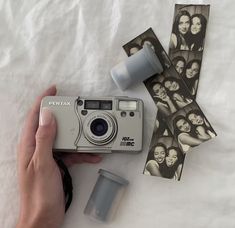 a person holding a camera next to some pictures on a sheet of paper and tape