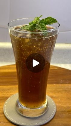 a glass filled with liquid sitting on top of a wooden table