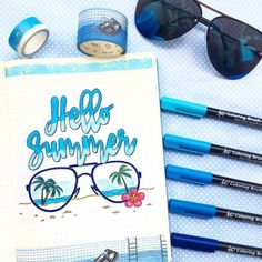 an open notebook with the words hello summer written on it next to some pens and sunglasses