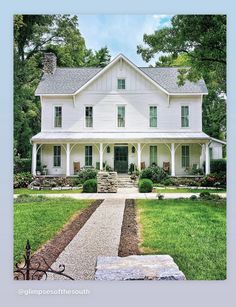 a large white house sitting on top of a lush green field