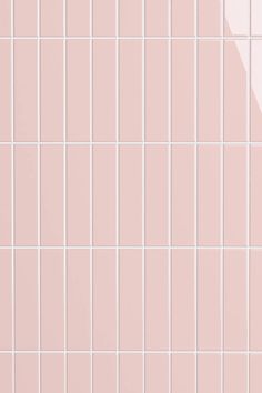 a pink tiled wall with white tiles on it