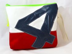 a red, white and blue purse with an arrow on the front is sitting against a white background