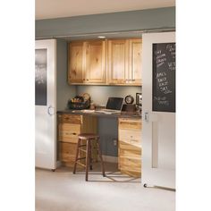 a kitchen with wooden cabinets and chalkboard on the wall