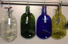 three empty wine bottles hanging from hooks on a wall