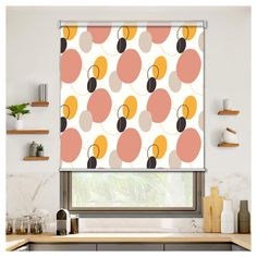 a kitchen window with an orange and pink pattern on the blind in front of it