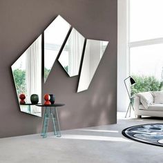 a living room with three mirrors on the wall and a table in front of it