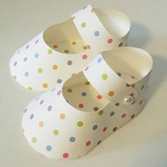 three pairs of paper shoes with polka dots on them