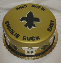 a cake that is on top of a white tablecloth with black and gold decorations