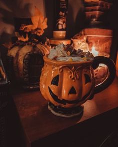 a pumpkin mug sitting on top of a wooden table