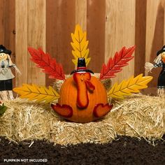 an image of a thanksgiving decoration made out of pumpkins and fall leaves on hay