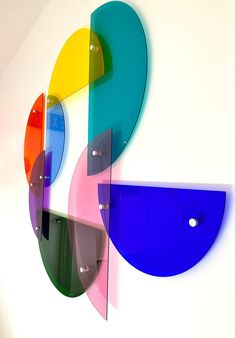 an abstract art piece on the wall with multiple colored circles and shapes painted on it